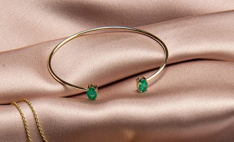 14k yellow gold bangle set with a matching pair oval Cut emerald